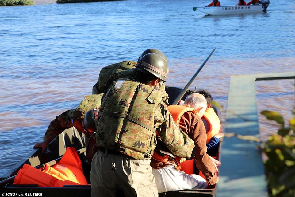 19680304-7570251-image-a-32_1571038315237 Rescue workers help residents evacuate an area after Typhoon Hagibis swept through Kawagoe, Saitama prefecture today