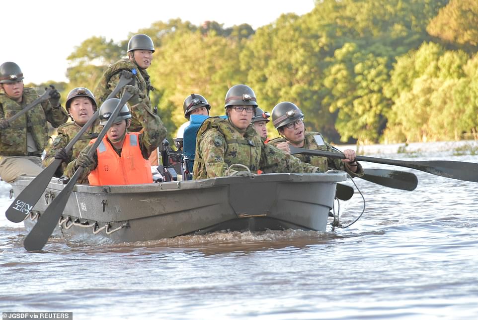 19680306-7570251-image-a-24_1571037946021 Rescue workers paddle a boat during evacuation operations today after Typhoon Hagibis swept through Kawagoe, Saitama prefecture