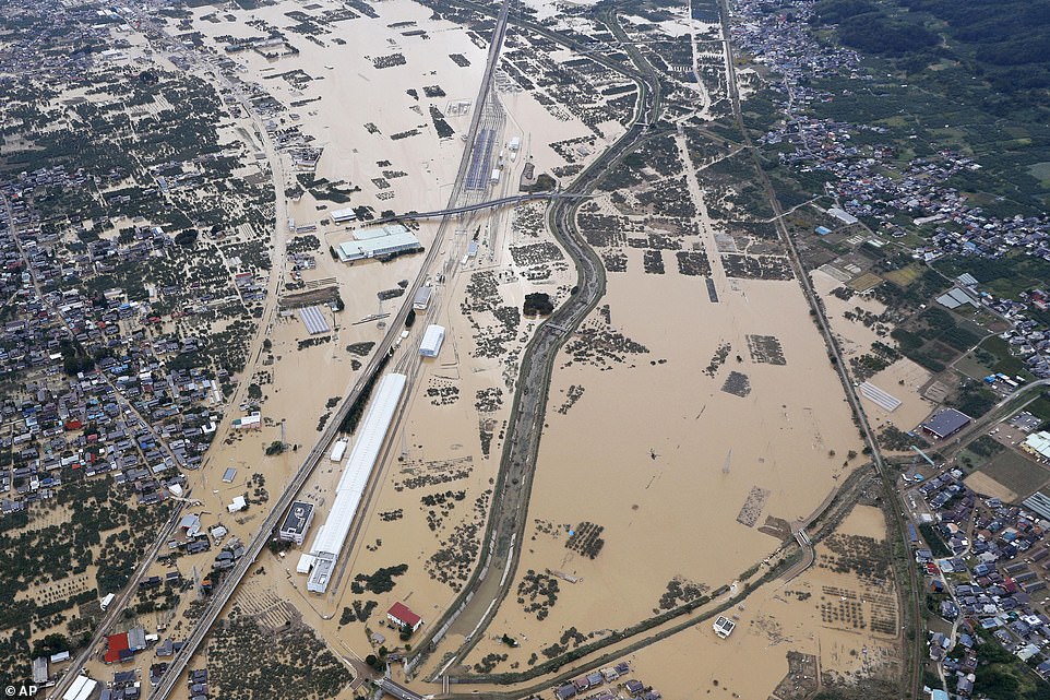 19680312-7570251-image-a-22_1571037941177 A flooded area in Nagano, central Japan, today. Some of the muddy waters in streets, fields and residential areas have subsided. But many places remained flooded, with homes and surrounding roads covered in mud and littered with broken wooden pieces and debris