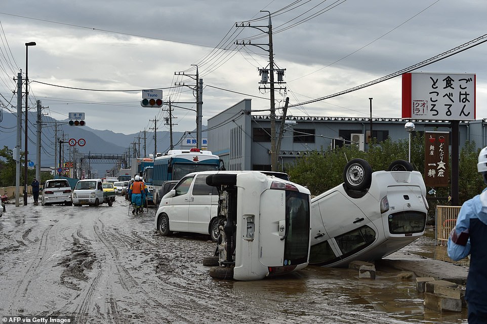 19680322-7570251-image-a-19_1571037931597 Overturned vehicles on the side of a muddy road today in the aftermath of Typhoon Hagibis in Nagano. It was the strongest typhoon this season and forced the suspension of many Japan railway services all over the country and cancelled about 1,600 domestic and international flights
