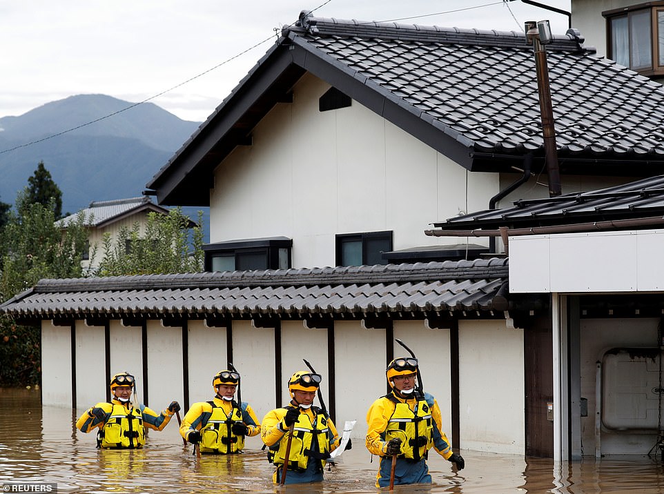 19680360-7570251-image-a-42_1571040914218 Rescue workers in goggles and snorkels searching a flooded area near the Chikuma River in Nagano as the hunt for survivors continued today