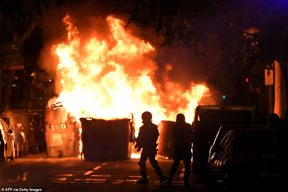 19813504-0-image-a-111_1571270080704 Catalan anti-riot police officers stand close to a burning barricade during a demonstration tonight, with residents warned to stay away from Barcelona's city centre