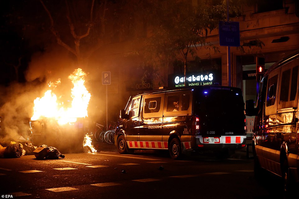 19813558-0-image-a-100_1571270014208 Spanish national police vans wait at a burning barricade during a protest against the Spanish Supreme Court's ruling of multiple jail terms for pro-independence leaders, in Barcelona