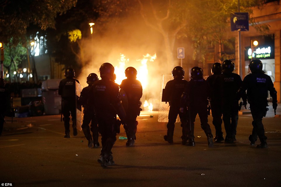 19813600-0-image-a-80_1571269888792 Spanish national police members guard a street during a protest against the Spanish Supreme Court's ruling of multiple jail terms for pro-independence leaders, in Barcelona