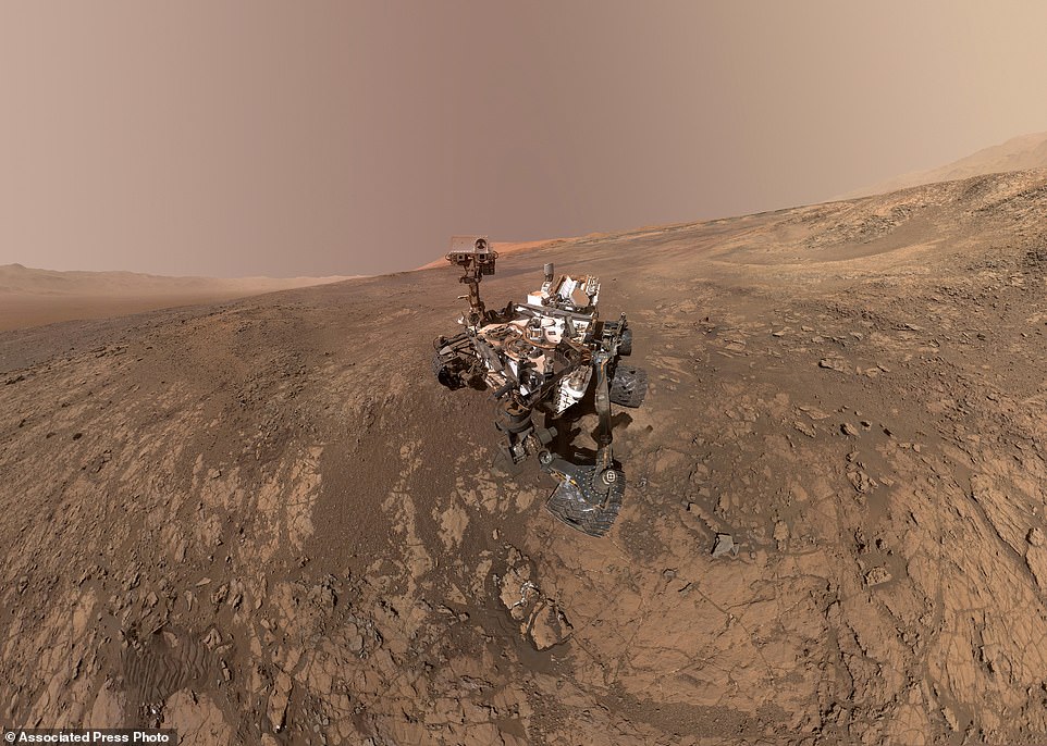 Nasa has transformed 'selfies' taken by its Mars rover Curiosity into a stunning self-portrait. Released this week, the photo (pictured) shows Curiosity in the middle of the dusty, red Martian terrain, with Mount Sharp in the background. The rim of Gale Crater is also visible. In this image north is on the left and west is on the right
