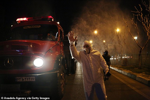 25832230-8099925-image-a-28_1583929337859 A worker signals to the camera during an attempt to stem the coronavirus outbreak with street disinfection in Tehran, Iran