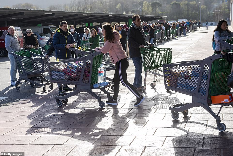25971894-8111805-image-a-75_1584205459435 Queues of trolleys wait to be allowed into a supermarket in Irun near San Sebastian after the Spanish government declared a state of emergency yesterday