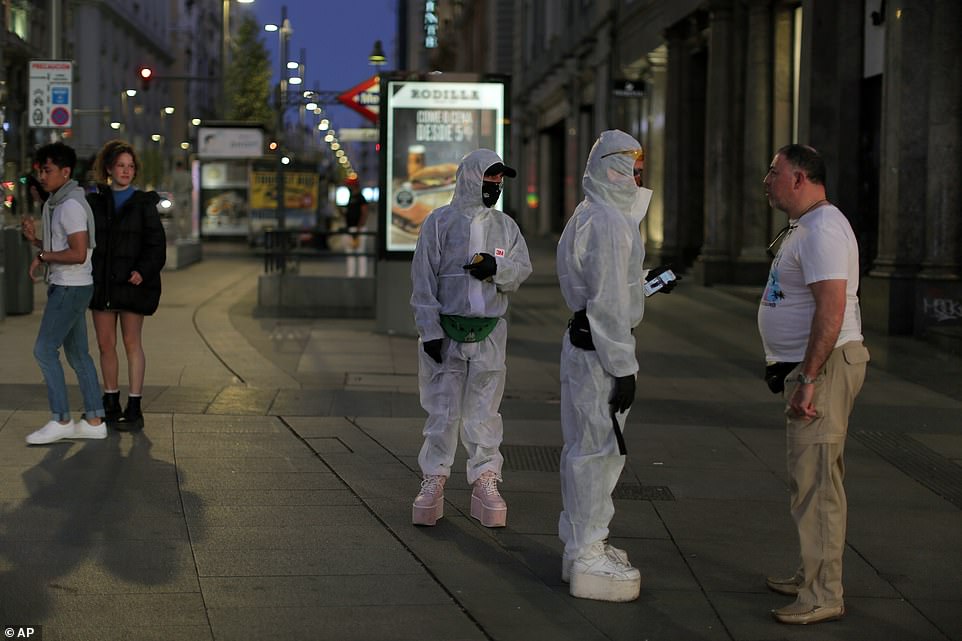25979998-8112691-image-a-15_1584227006067 British holidaymakers and students in Spain are desperately trying to return home before the country's announces the most severe coronavirus measures in Europe. Pictured: People wearing hazmat suits in downtown Madrid