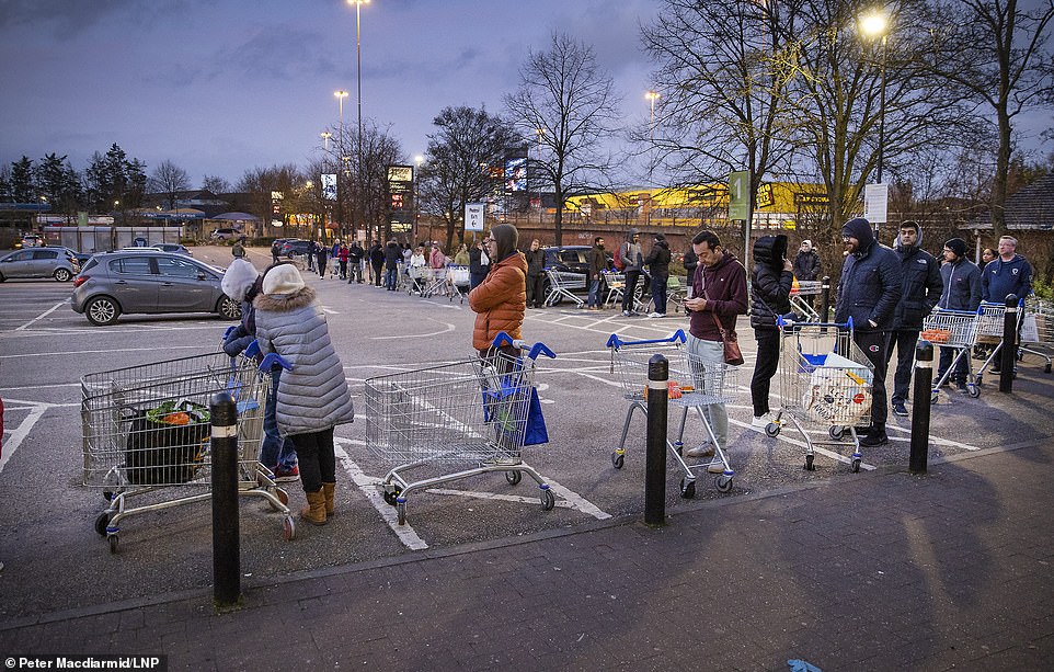 26234872-8137409-image-a-24_1584780619536 Tesco is even hiring 20,000 shelf stackers on 12-week contracts. Pictured are shoppers queuing outside Tesco at 5.40am in New Malden