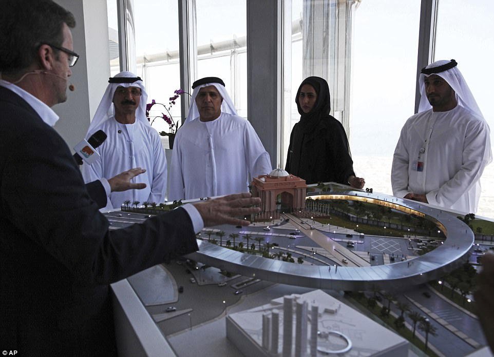 Rob Lloyd, the CEO of Hyperloop One, left, shows a model to Emirati officials including Mattar al-Tayer, the director-general and chairman of Dubai's Roads & Transport Authority, third left, in Dubai