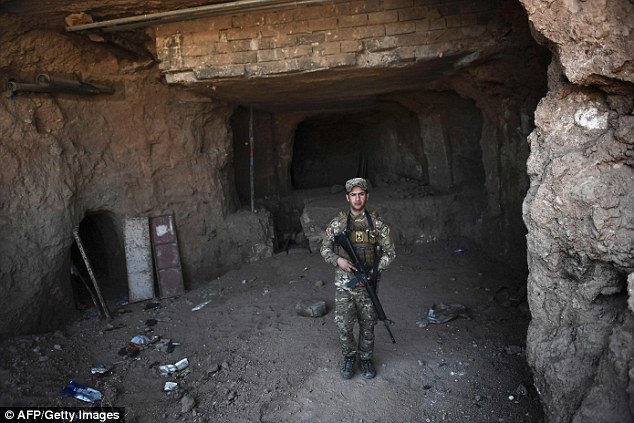 An Iraqi soldier standing in a section of excavated ISIS tunnel. It had long been rumoured that the shrine shared a site with an ancient palace. Excavations had previously been carried out by the  Iraqi department of antiques in the 1950s, but they found nothing