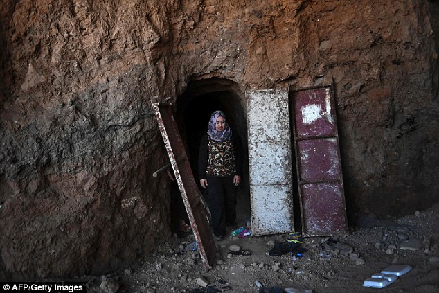 Mrs Salih, pictured here coming from the entrance of one of the ISIS tunnels, is leading a five-person team carrying out the emergency documentation of Jonah's tomb. She believes that ISIS forces looted hundreds of objects before Mosul was retaken by Iraqi forces