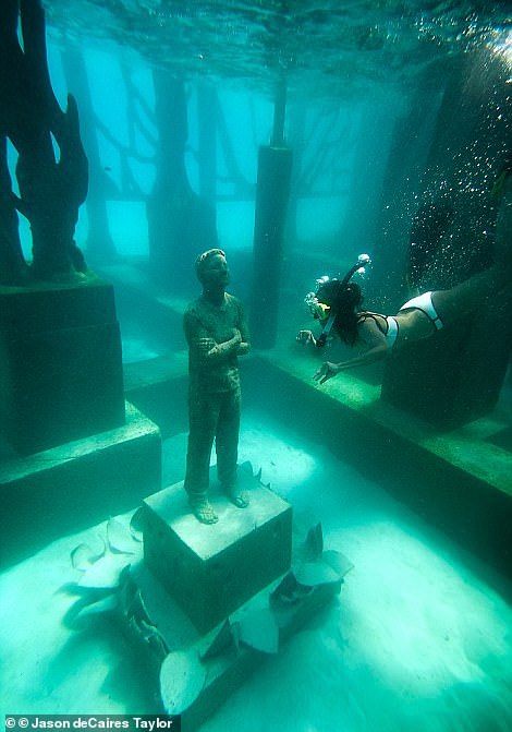 4531988-6205159-image-a-30_1537870702689 A tourist inspects one of the statues