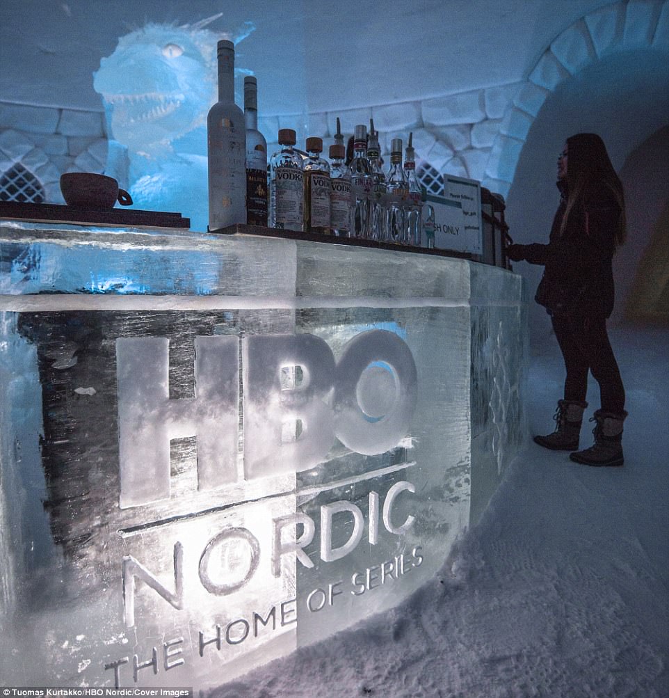 A customer stands at the bar ready to order her drink, which will be served in a glass that has been carved out of ice 