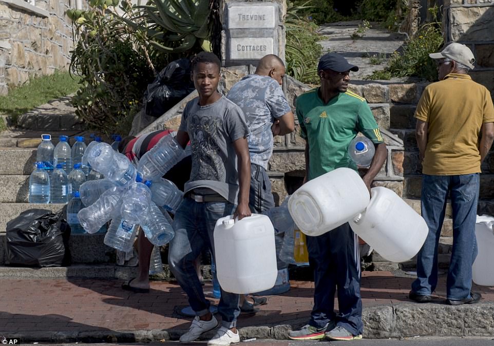 Bottled water is being rationed in shops in Cape Town to prevent panic-buying and hoarding as the drought-ridden city faces 'the worst crisis since 9/11' ahead of its taps running dry. People are pictured queuing to collect water in the city last week