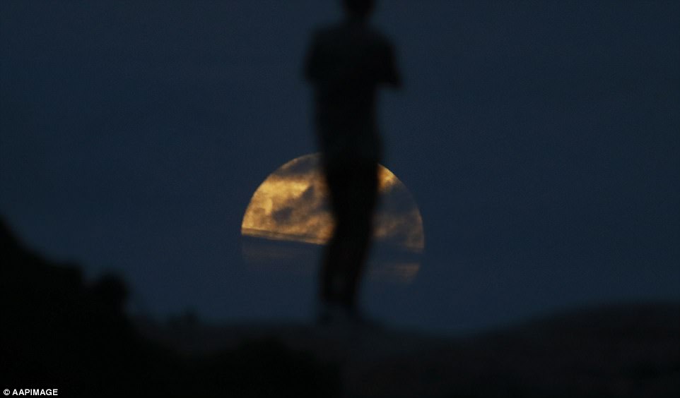 The partial eclipse began at around 11.48am GMT, before reaching its peak at 1.29pm GMT. According to Sky and Telescope, the last blue moon total lunar eclipse visible from North America happened on March 31, 1866. A man takes pictures as the moon rises near Bondi beach