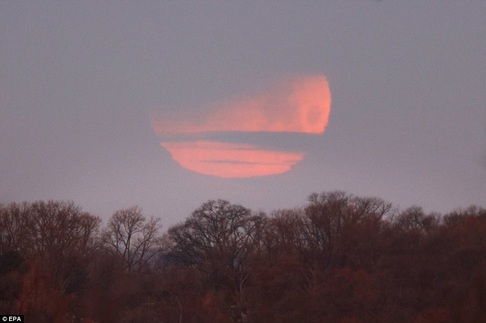 The partial eclipse is seen just above the horizon in Washington. The darker part of Earth's shadow began to blanket part of the moon with a reddish tint at 6:48 am EST (11:48 GMT)