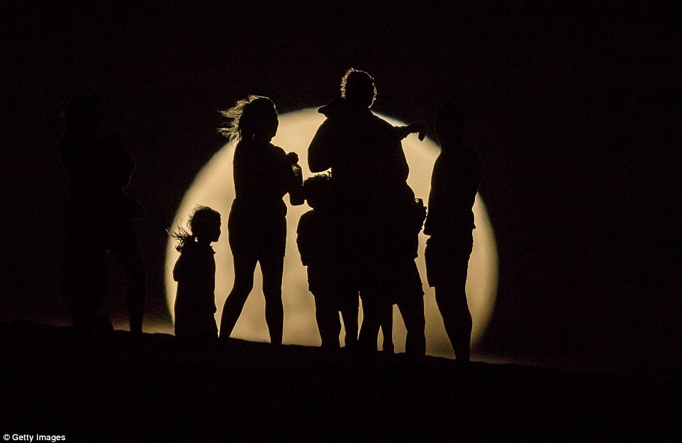 People watch the the Super moon rising in the sand dunes on January 31, 2018 in Lancelin, Australia. Last seen from Australia in December 1983, a Super Blue Blood Moon is the result of three lunar phenomena happening all at once