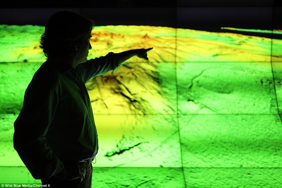 Also discovered in Tika were a series of pits and a 14 kilometre-long wall. The pyramid measures nearly 100 feet (30 meters) tall and was previously thought to be a small mountain. Pictured is a researcher looking at their finds 