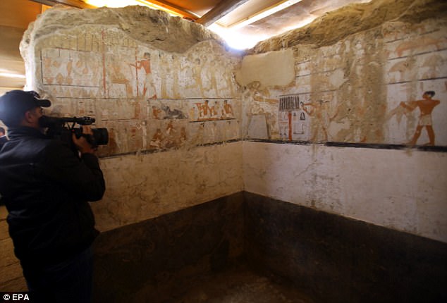 An Egyptian cameraman films wall paintings inside the tomb of the Old Kingdom priestess on the southern outskirts of Cairo