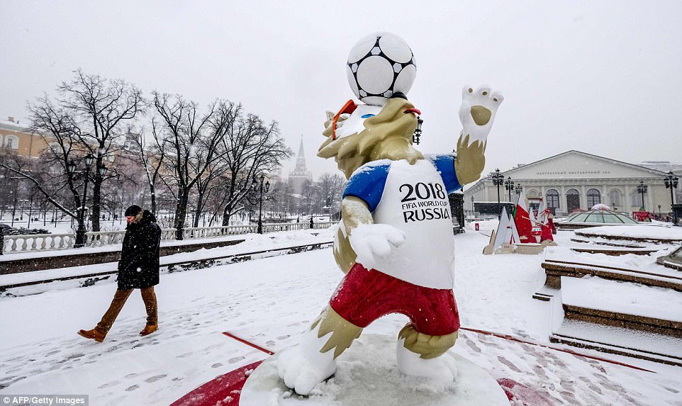 A man wraps up warm as he walks past a statue of Zabivaka - the country's official 2018 FIFA World Cup mascot - in Manezhnaya Square, downtown Moscow 