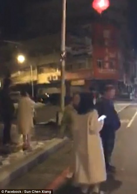 Pictures show the aftermath of the earthquake with people in the streets inspecting the damage to roads and buildings