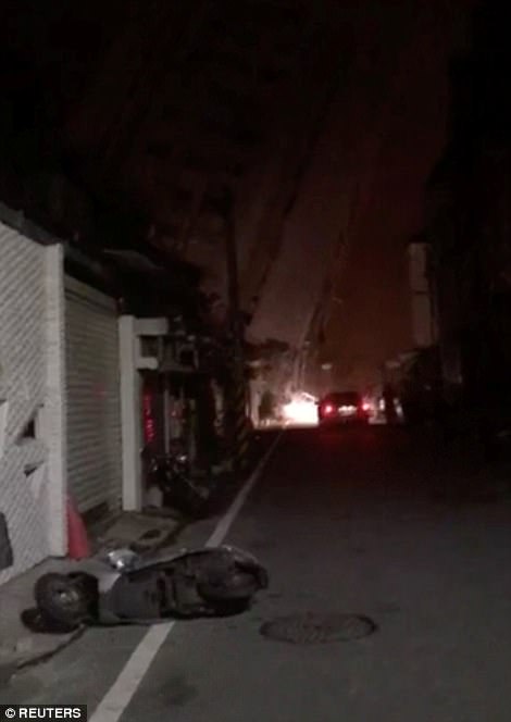 Pictures show the aftermath of the earthquake with people in the streets inspecting the damage to roads and buildings