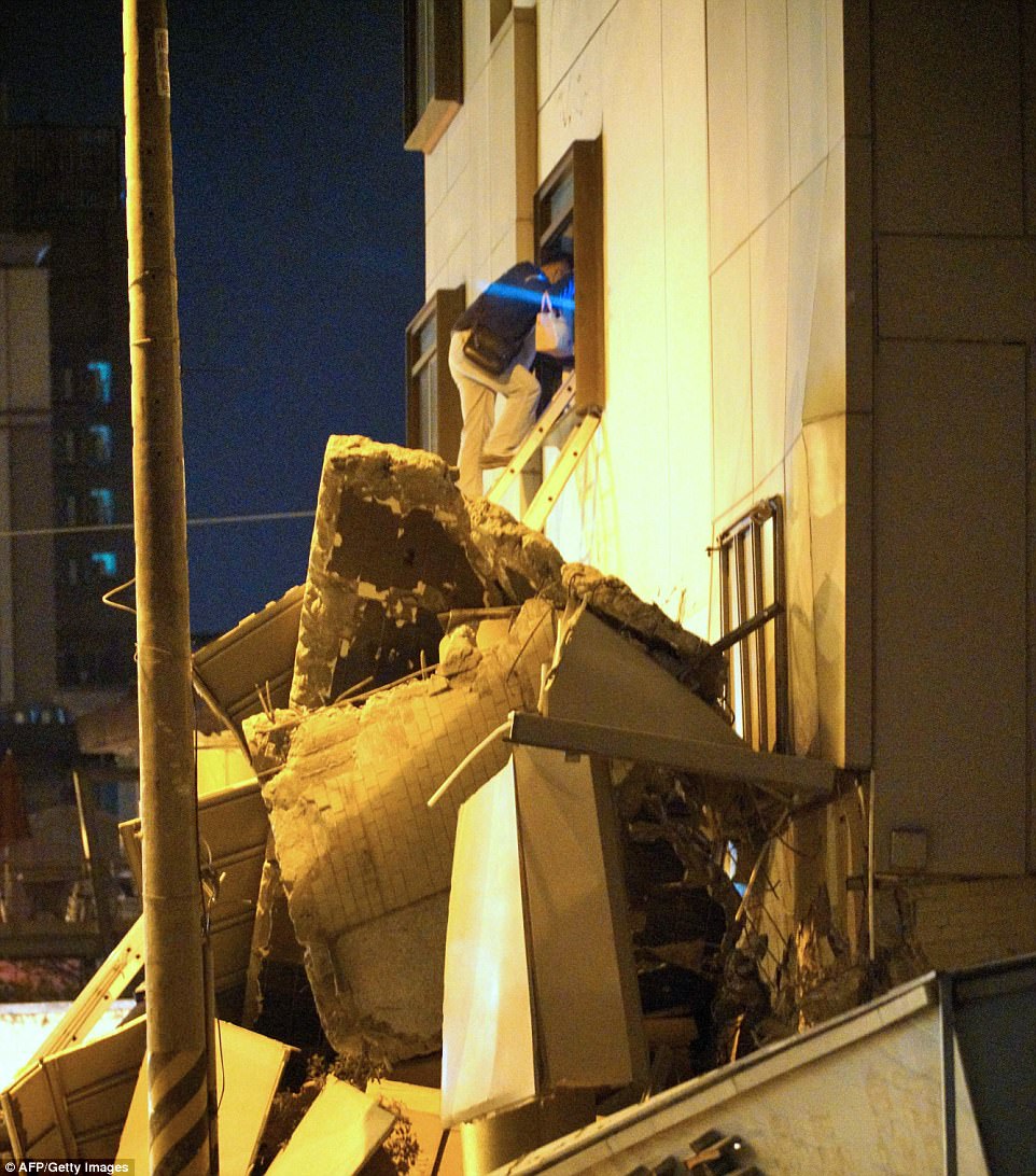 A man climbs a ladder over rubble at the damaged Marshal Hotel in Hua-lien, Taiwan, following the earthquake