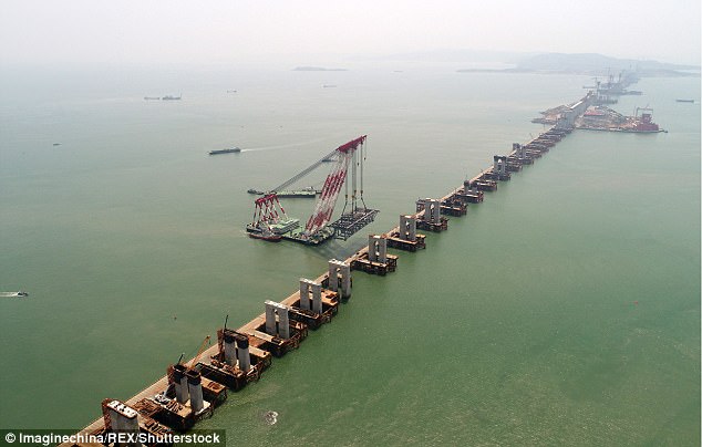 Mission impossible: Chinese workers are building a high-speed railway bridge (pictured) off the coast of south-east China, which is a 'no-go zone' for bridge builders due to high winds