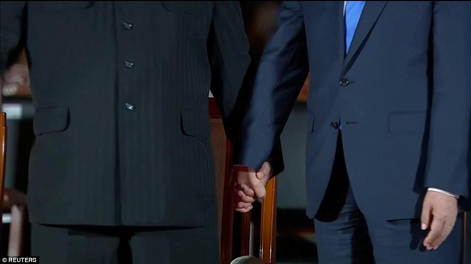 As pop music blared, Kim and Moon firmly grasped each other's hands Friday during a lavish farewell ceremony at the border truce village of Panmunjom