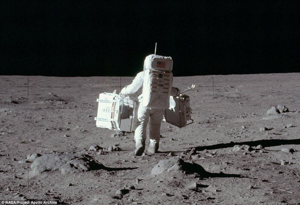 Aldrin carries scientific equipment across the moon's surface to conduct seismic experiments and collect samples