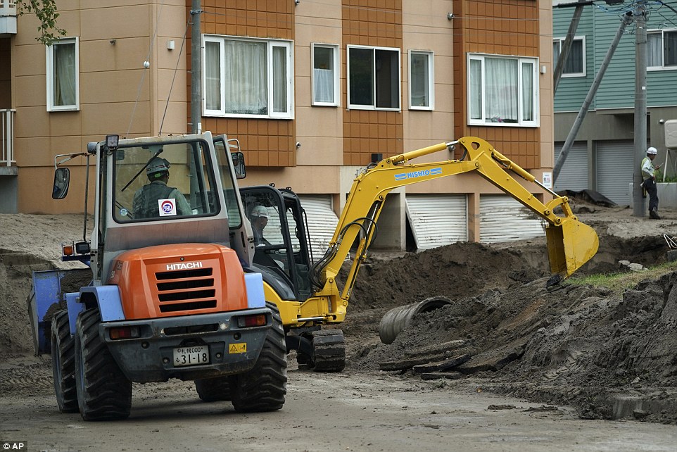 4fdcb3fd00000578-6145357-image-a-16_1536395858950 Workers remove the mud caused by ground liquefaction from a street after a powerful earthquake in Kiyota ward of Sapporo, Hokkaido, northern Japan, on Saturday. Thursday's powerful earthquake hit wide areas on Japan's northernmost main island of Hokkaido. Some parts of the city were severely damaged, with houses left tilting and roads crumbled or sank