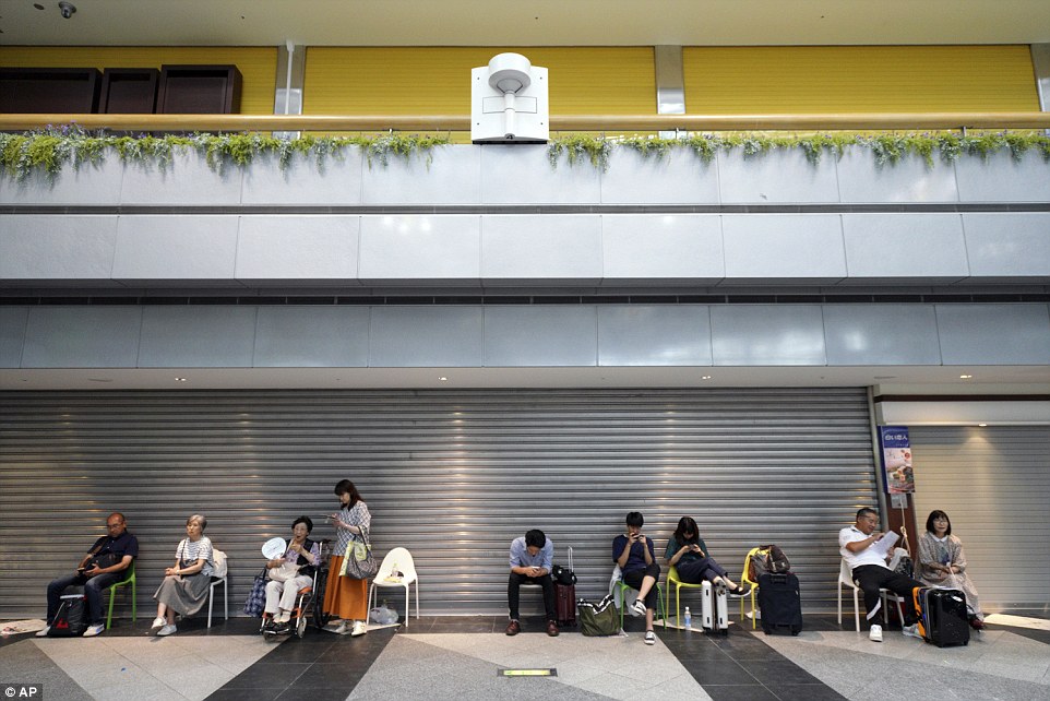 4fdd23a000000578-6145357-image-a-24_1536396054090 International flights at the main airport in Sapporo resumed operations on Saturday, while bullet trains began service the day before. Above: stranded passengers wait for flights to start at New Chitose Airport