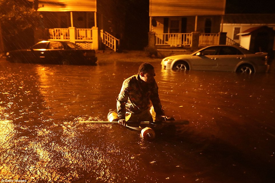 Michael Nelson uses a boat made from a metal tub and fishing floats after the Neuse River went over its banks and flooded on Thursday