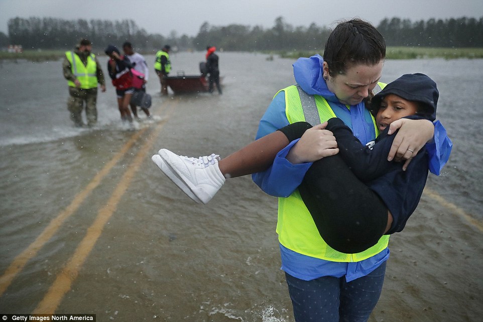 502e443800000578-6170371-image-a-49_1536988276285 Volunteer Amber Hersel from the Civilian Crisis Response Team helps rescue 7-year-old Keiyana Cromartie and her family from their flooded home on Friday in James City, just across the Trent River from New Bern