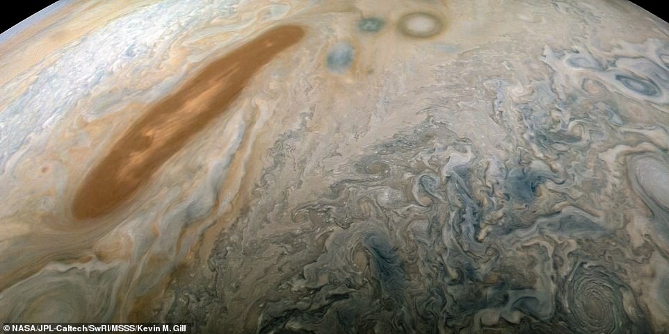7387240-6492387-image-a-25_1544717461481 Stunning footage captured by NASA's Juno probe has been released as it reaches the halfway point of its mission to explore Jupiter. A long, brown oval known as a 'brown barge' in Jupiter's North North Equatorial Belt is captured in this colour-enhanced image from NASA's Juno spacecraft