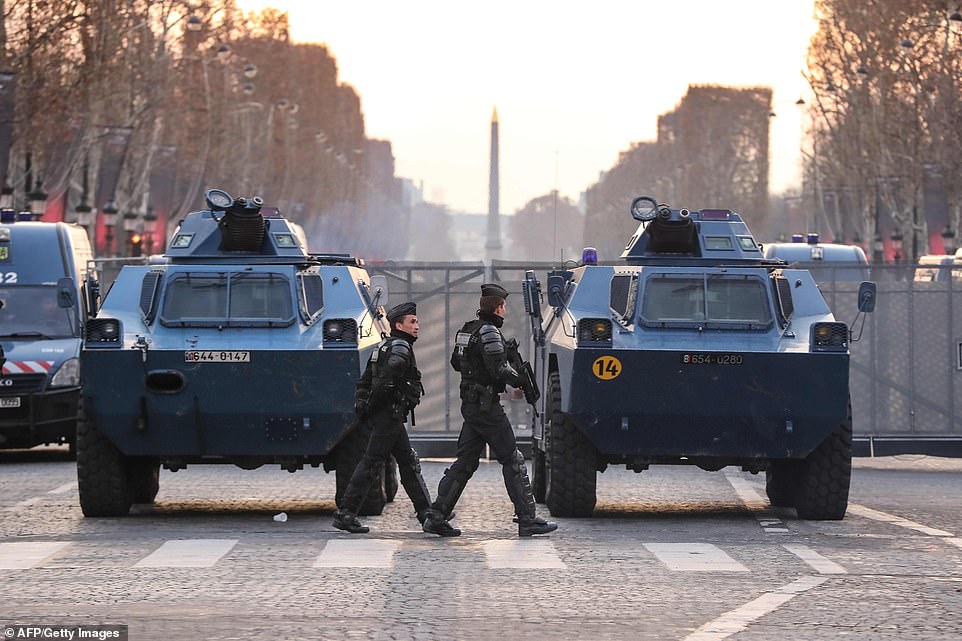 7456696-6498733-image-a-11_1544866607201 The armed officers patrol in front of Gendarmerie with armoured vehicles parked on the Champs Elysees,