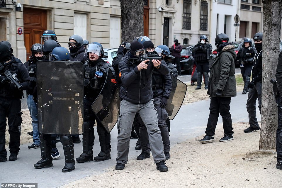 7458132-6498733-image-a-41_1544871093562 A French police officer aims his Lanceur de balle de defense (LBD40) weapon, which fires rubber bullets, as protests kick off in the capital this morning