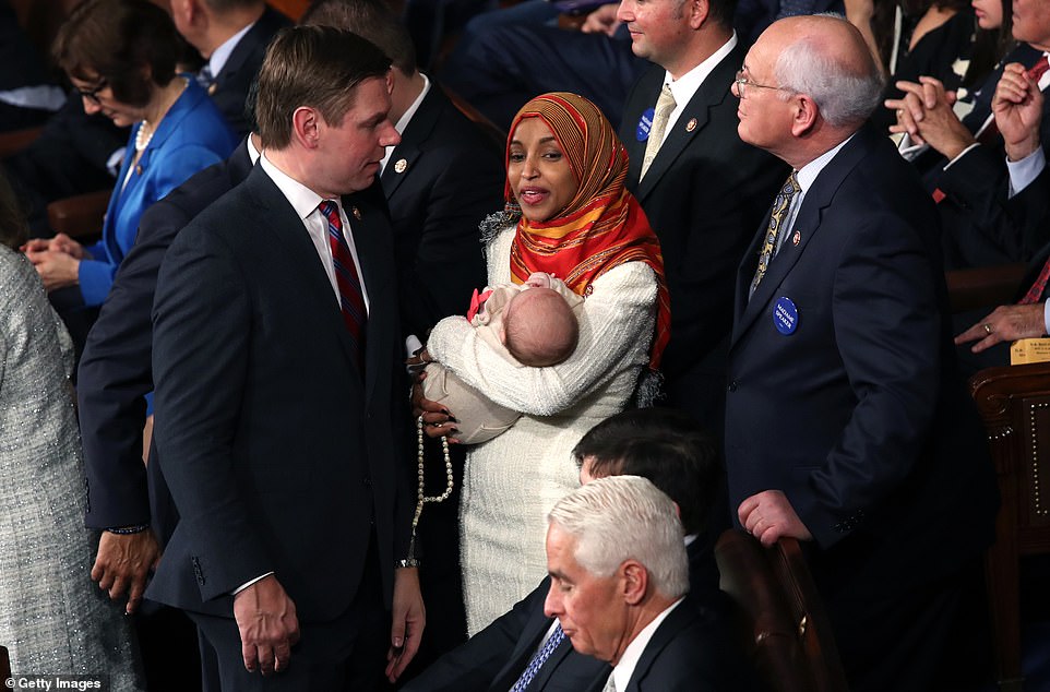 8099170-6555271-image-a-143_1546544585425 Hi baby: Ilhan Omar holds fellow Democratic congressman Eric Swalwell's young baby as she mingles with members of the Democratic caucus
