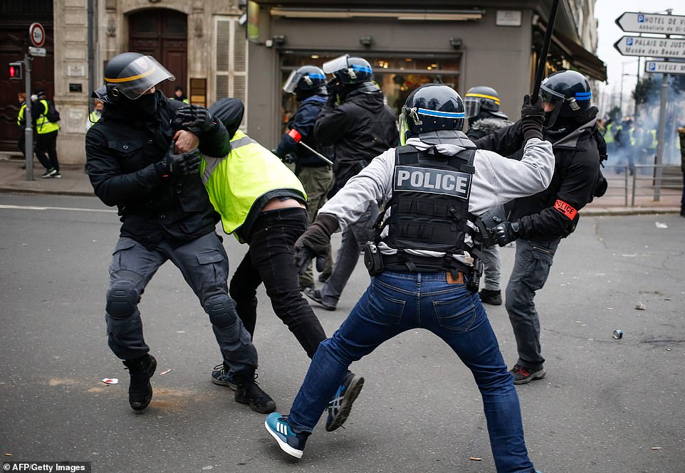 8157802-0-image-a-4_1546691403053 A yellow vest protestor is beaten with a baton during protests in Rouen. This is the eighth Saturday of protests called by the grass-roots movement. The numbers turning out have fallen steadily since the start of the demonstrations in November