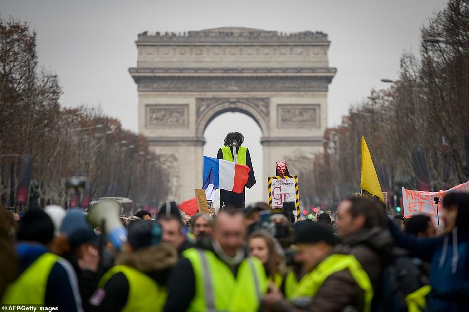 8157808-0-image-a-18_1546691528882 Yellow vest protestors hoist an effigy with a French national flag in front of The Arc de Triomphe on The Champs-Elysees in Paris today. In Paris, organisers called for a march from the City Hall to the National Assembly (parliament) building, and a rally on the Champs Elysees, the scene of violent clashes at previous demonstrations