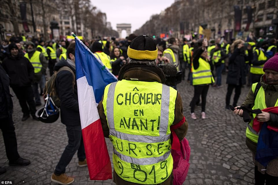 8157810-0-image-a-11_1546691492952 A protester wears a yellow vest with a slogan reading 'unemployed walk' during a 'Yellow Vests' protest march on the Champs Elysees boulevard, in Paris