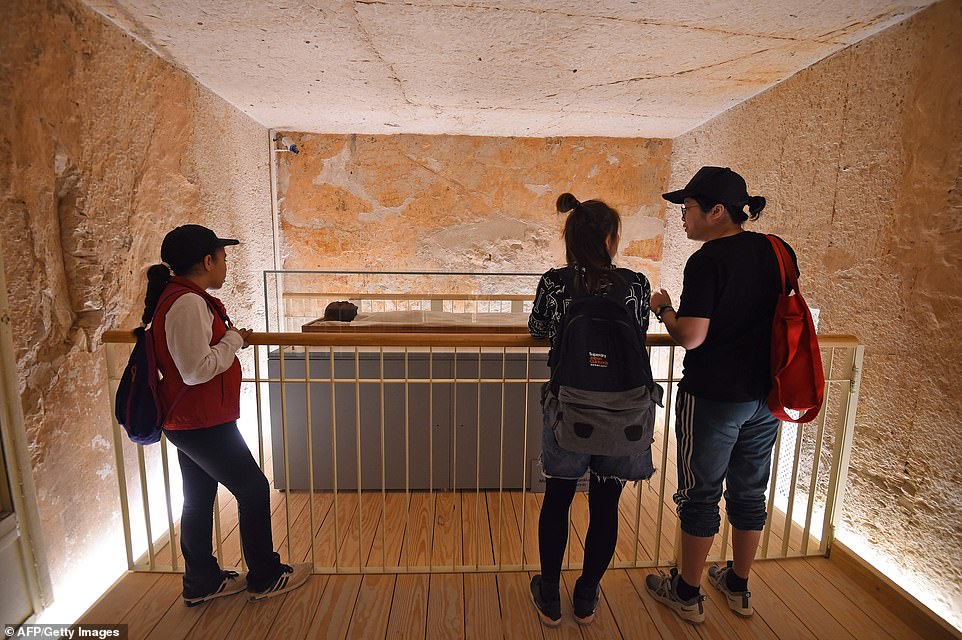 A group of tourists view the linen-wrapped mummy of of the 18th dynasty Pharaoh Tutankhamun, taking in his mummified body 