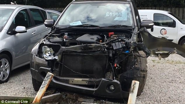 Police closed the road near St Austell for eight hours as they examined the damage ¿ expected to run into tens of thousands of pounds - at Andrew Toms Car Sales