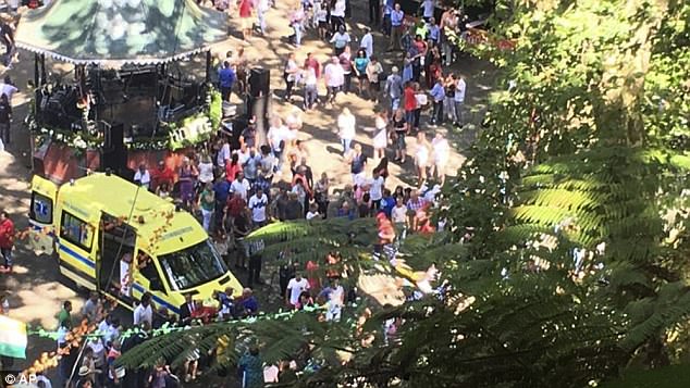 An ambulance attends the scene as revellers look for loved ones in the crowd