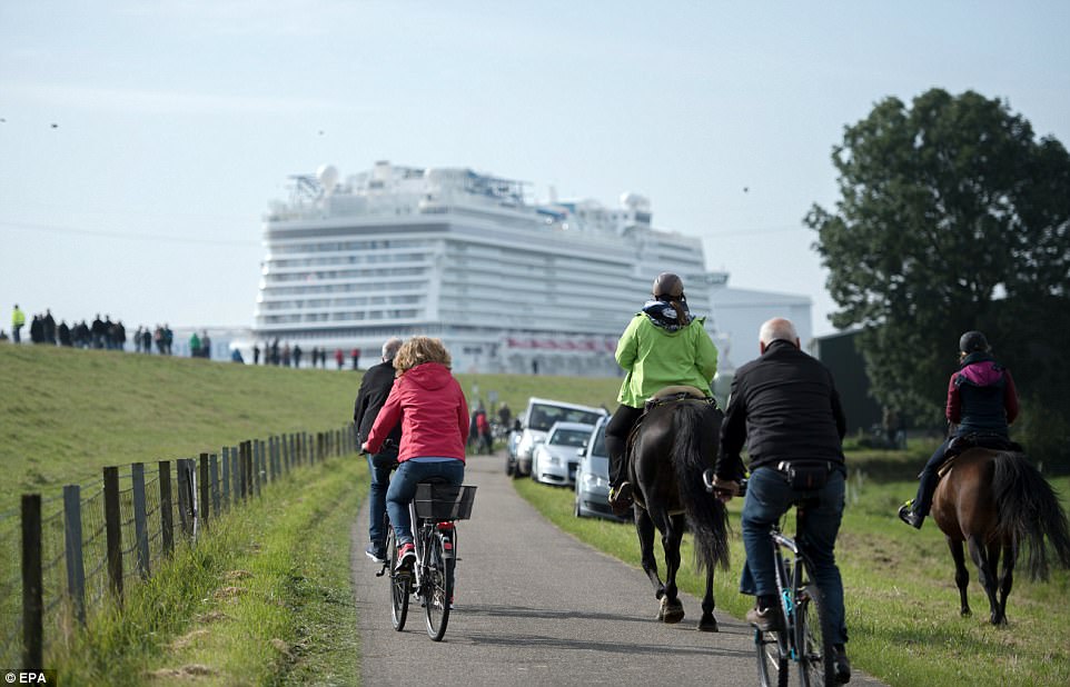 Crowds gather as cruise ship 'World Dream' leaves the Meyer shipyard port for the transfer on the Ems river in Papenburg