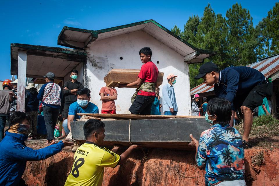 Locals help each other to carry their loved ones coffins, in hope of getting a good harvest