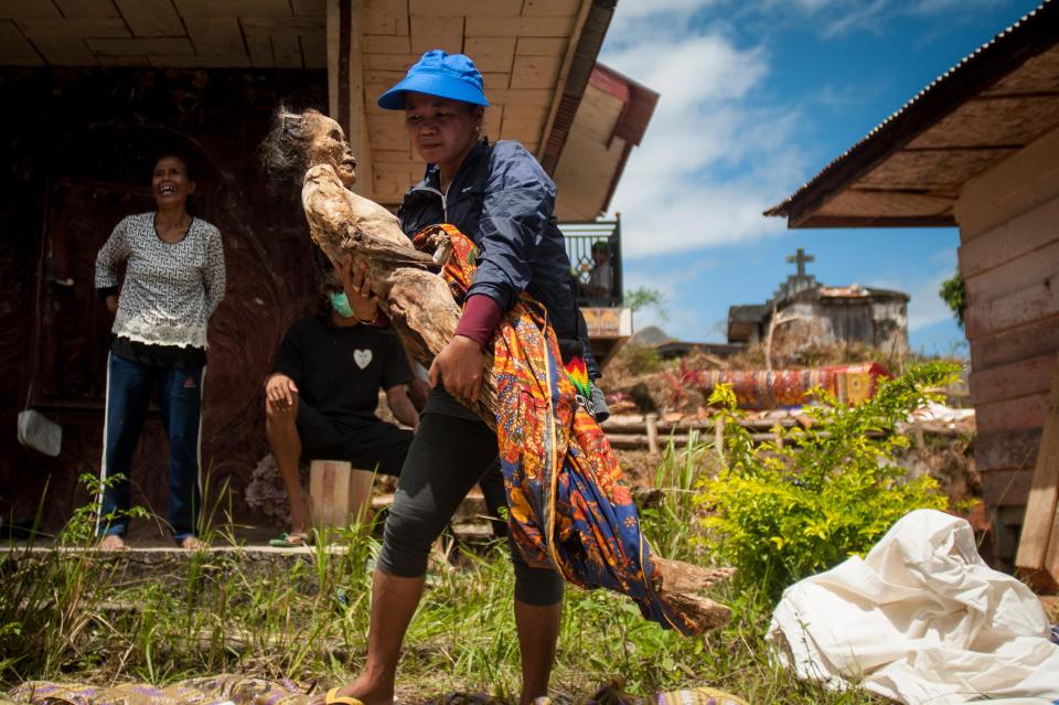 This woman is carrying her relative's corpse across her farmland - in hope that the corpse will bring them a good harvest