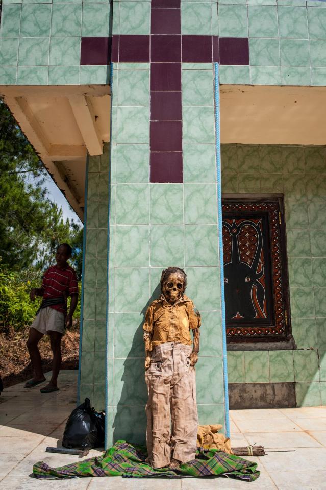 A child's corpse is placed beneath a crucifix mosaic