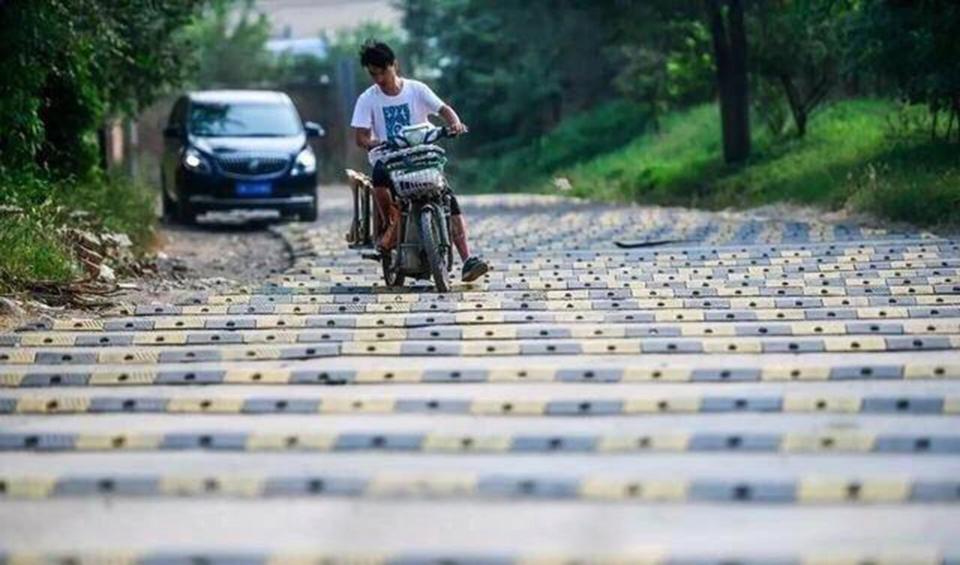 A Chinese man on a scooter attempts to navigate the bone-rattling road